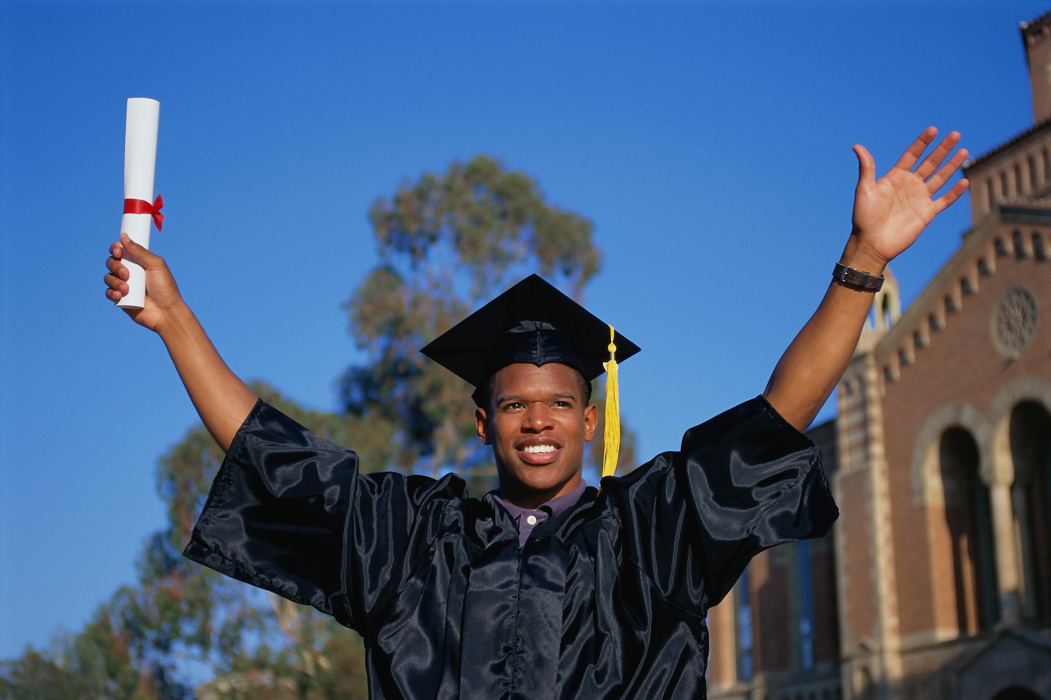 PERBE081 Young man celebrating college graduation,
