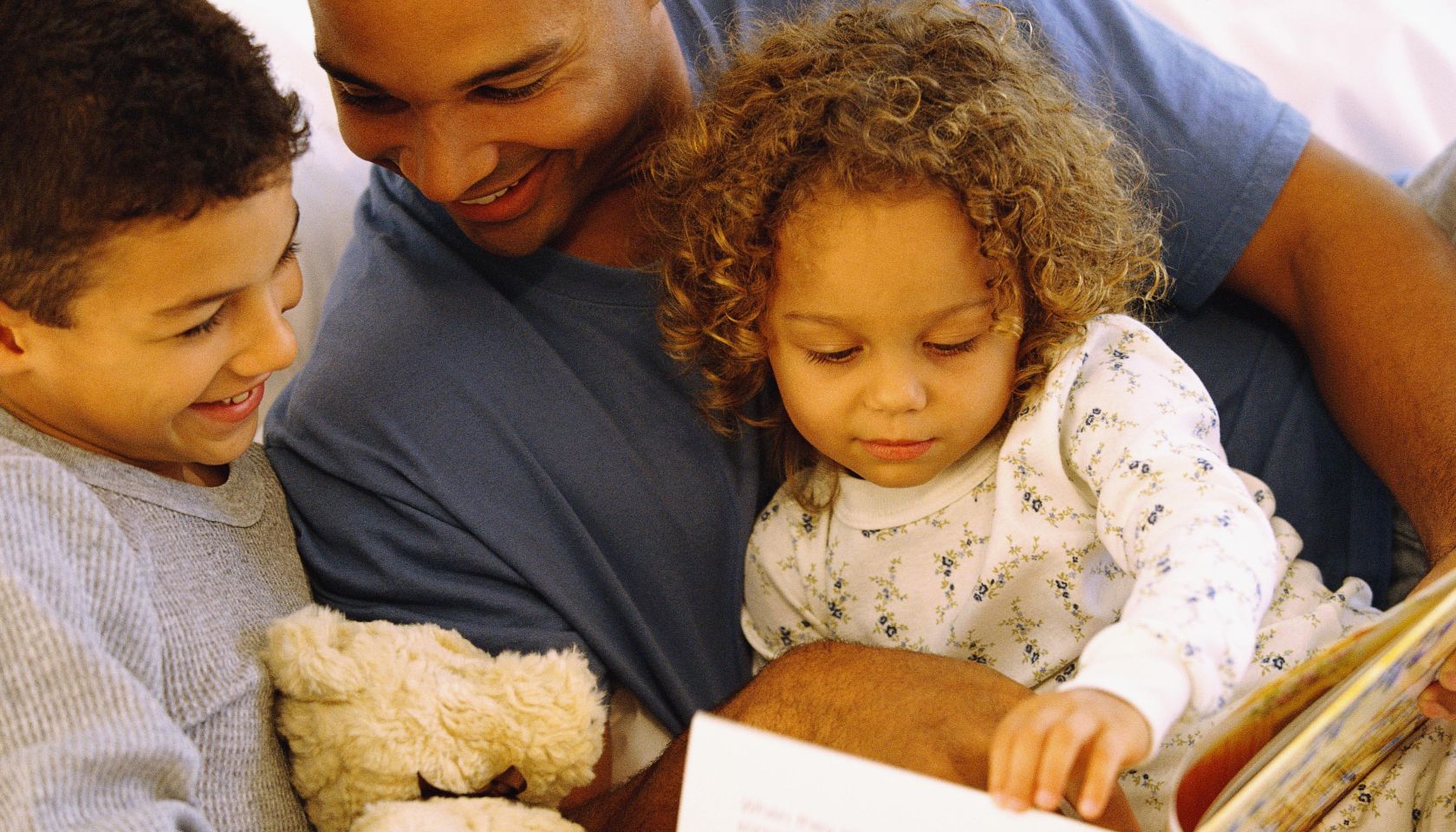 Father reading story to daughter and son